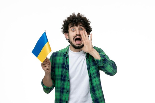 Ukraine russian conflict cute young brunette guy green shirt and ukrainian flag calling for help
