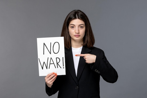 Ukraine russian conflict cute young dark hair woman in black blazer holding no war sign