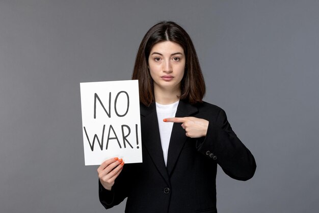 Ukraine russian conflict cute young dark hair woman in black blazer holding no war sign