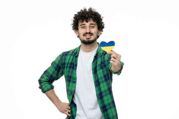 Украина русский конфликт милый молодой парень в зеленой рубашке держит украинское сердце отдавая сердце