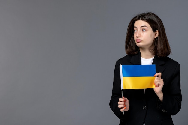 Ukraine russian conflict gorgeous young dark hair woman in black blazer looking up and dreaming