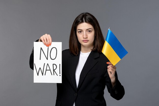 Ukraine russian conflict gorgeous young dark hair woman in blazer holding no war sign serious