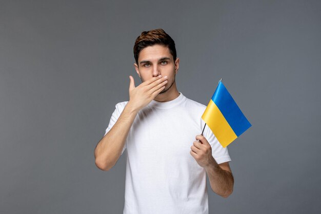 Ukraine russian conflict handsome courageous guy in white shirt showing silence sign