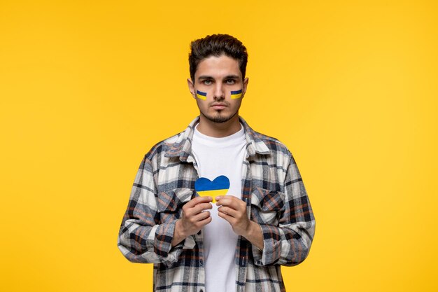 Ukraine russian conflict handsome courageous guy with flags on cheeks praying for ukraine