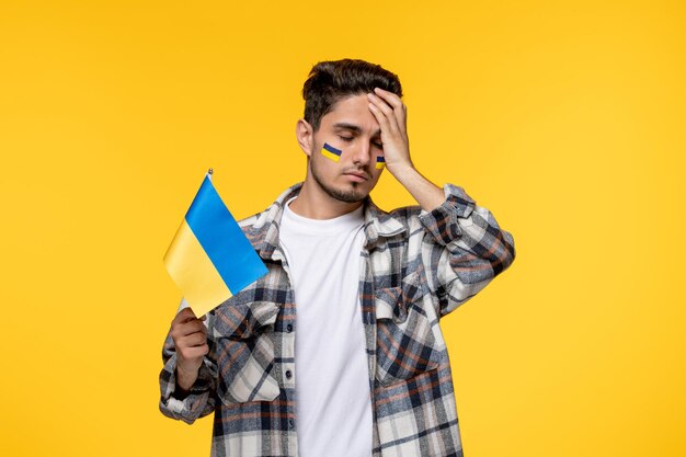 Ukraine russian conflict handsome courageous guy with flags on cheeks upset about war in ukraine