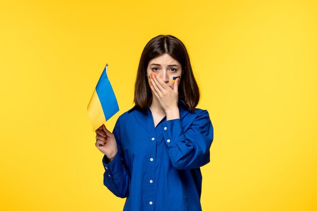 Ukraine russian conflict pretty cute girl with flags on cheeks crying with ukrainian flag