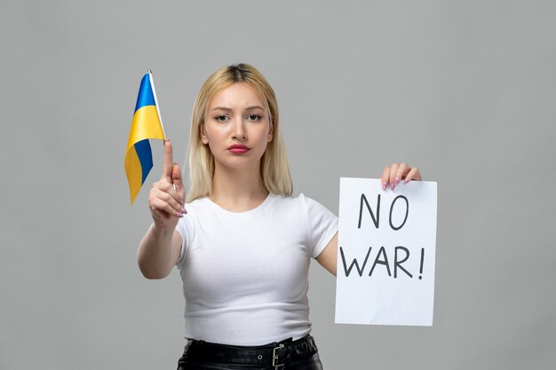 Ukraine russian conflict young cute girl holding no war sign and ukrainian flag