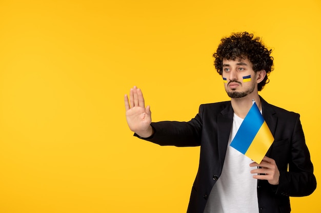 우크라이나 러시아 충돌 플래그를 들고 얼굴에 우크라이나 국기와 함께 검은 블레이저에 젊은 남자