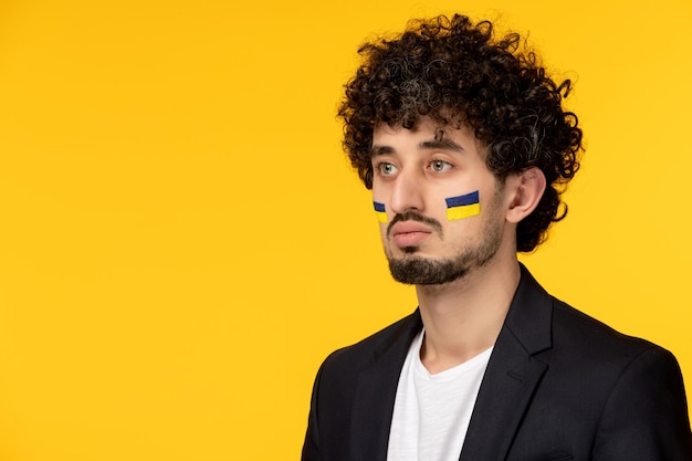 顔にウクライナの旗を描いたブレザーのウクライナロシア紛争若い男クローズアップ