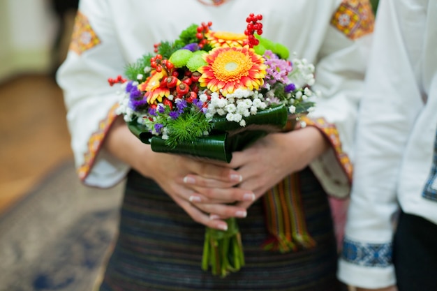 美しいカラフルな秋の花束を保持しているネイティブの刺繍でウクライナの花嫁