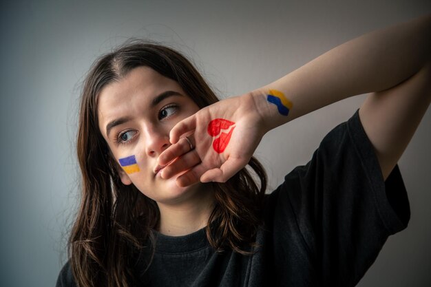 Ukrainian girl with a broken heart drawn on her hand pain for ukraine