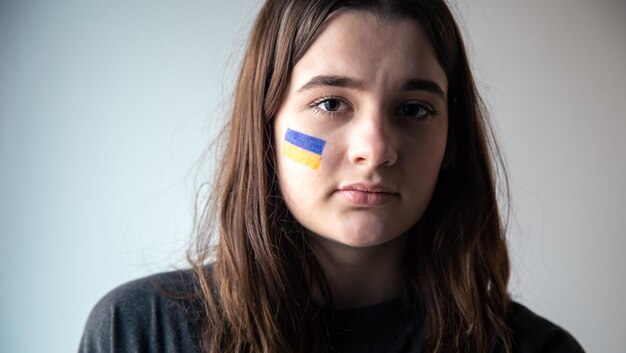 그녀의 얼굴에 우크라이나 국기를 그린 우크라이나 소녀