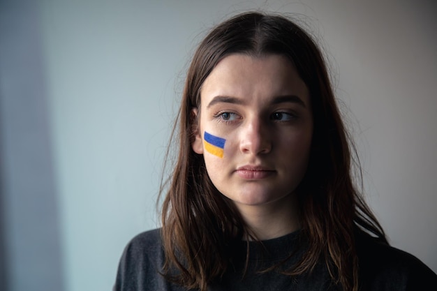 Free photo a ukrainian girl with a painted flag of ukraine on her face