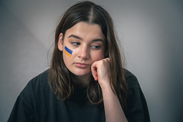 A ukrainian girl with a painted flag of ukraine on her face