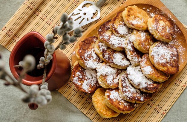 소박한 스타일로 만든 우크라이나 및 몰도바 전통 설탕 가루 치즈 팬케이크 시르니키
