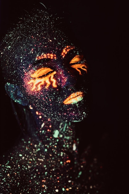 자외선 메이크업. 형광 가루로 칠한 소녀의 초상화. 할로윈 개념입니다.