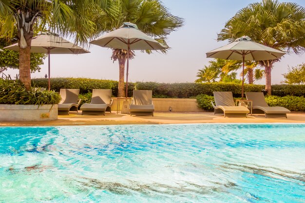 Umbrella and chair around beautiful luxury swimming pool