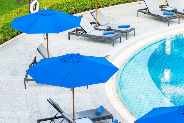 Umbrella and chair around outdoor swimming pool in hotel resort