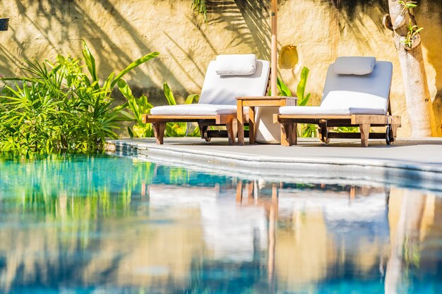 휴가 레저를위한 리조트 호텔의 야외 수영장 주변 우산과 의자