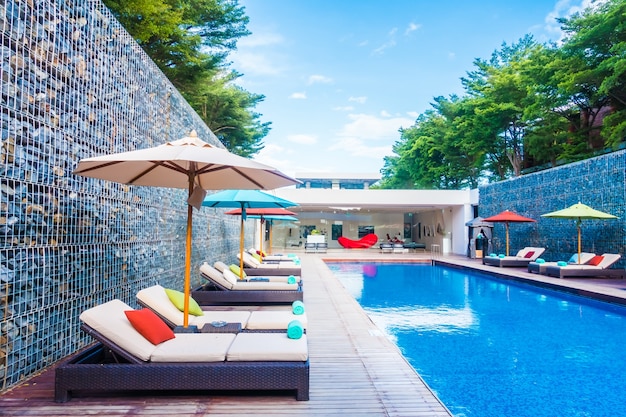 Umbrella and chair around swimming pool