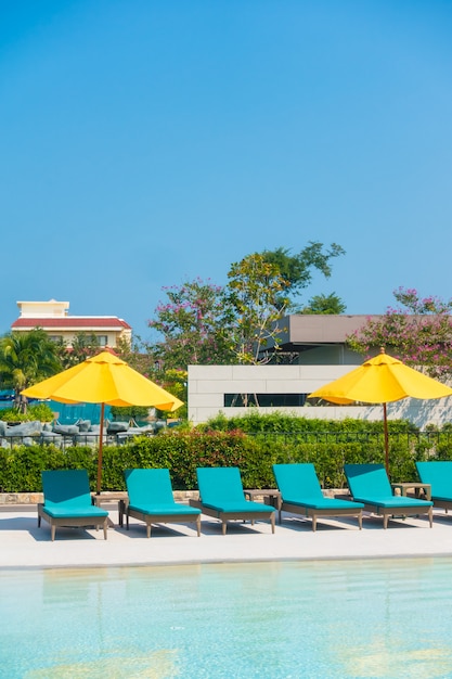 Umbrella and chair around swimming pool