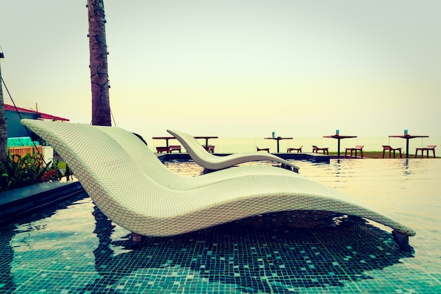 Poolside Relaxation: Umbrella and Chair – Free Stock Photo Download