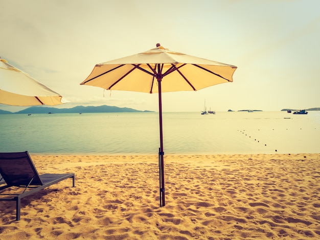 일출 시간에 열 대 해변 바다와 바다에 우산과 의자