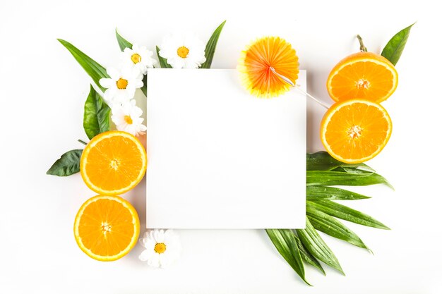 Umbrella and paper sheet near oranges and flowers