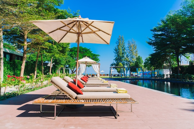 Foto gratuita piscina con ombrellone e sedia