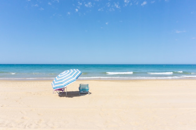 Umbrella and two deck chairs at the beach