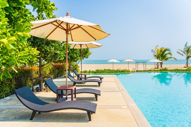 Umbrellas and deck chairs around outdoor swimming pool