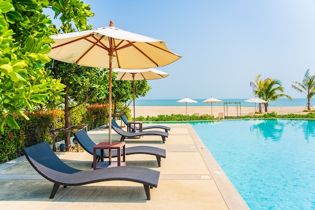 Umbrellas and deck chairs around outdoor swimming pool