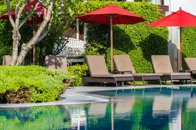 Umbrellas and deck chairs around outdoor swimming pool