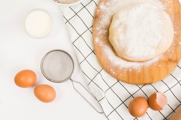 Unbaked pastry dough and raw ingredient over white surface