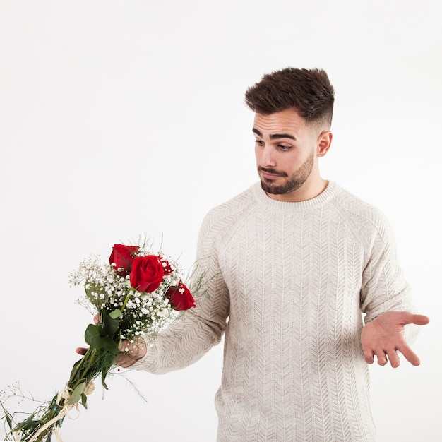 Free photo uncertain man looking at bouquet