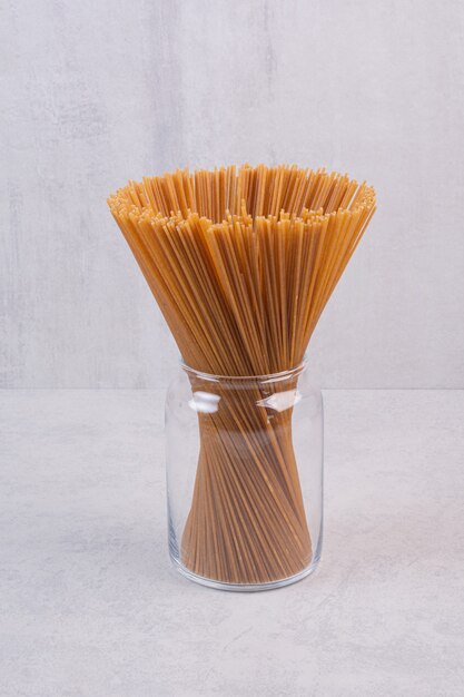 Uncooked brown spaghetti in glass jar