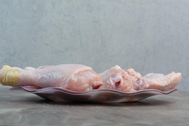 ピンクのプレートに未調理の鶏の脚。高品質の写真