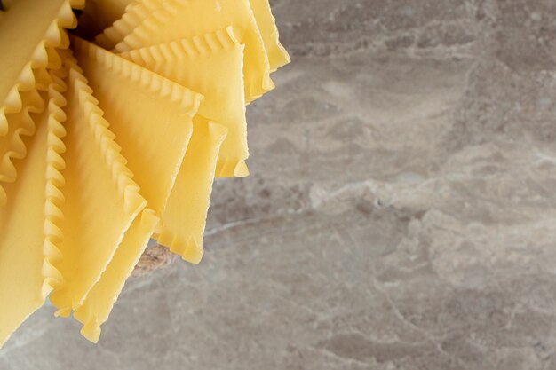 Uncooked dry pasta on marble surface