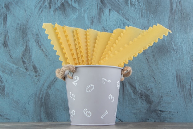 Uncooked dry pasta in metal bucket