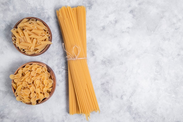 Uncooked dry pasta placed on a marble background . High quality photo