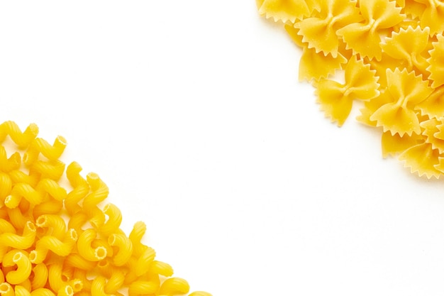 Uncooked farfalle and cellentani with copy space