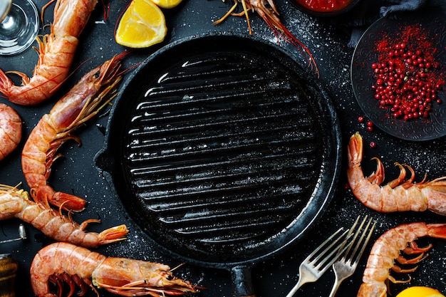 Uncooked giant shrimps on dark table