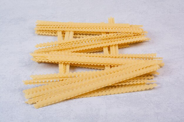 Uncooked long pasta on stone surface