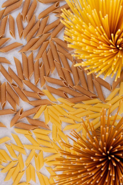 Foto gratuita maccheroni crudi con pasta fresca cruda su uno spazio bianco.