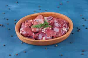 Free photo uncooked offal in a bowl on the blue surface