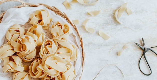 Free photo uncooked pappardelle pasta on a wooden basket