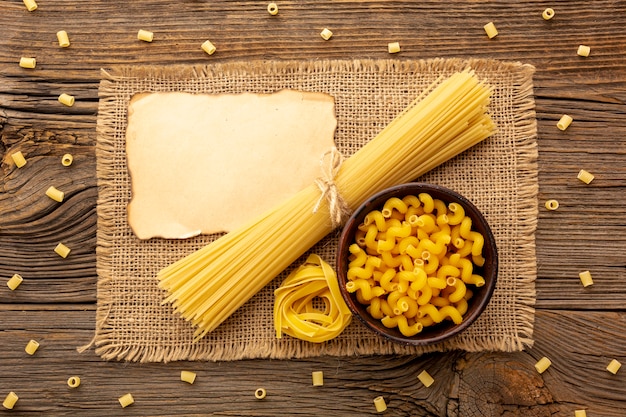 Foto gratuita mix di pasta cruda con modello di carta bruciata