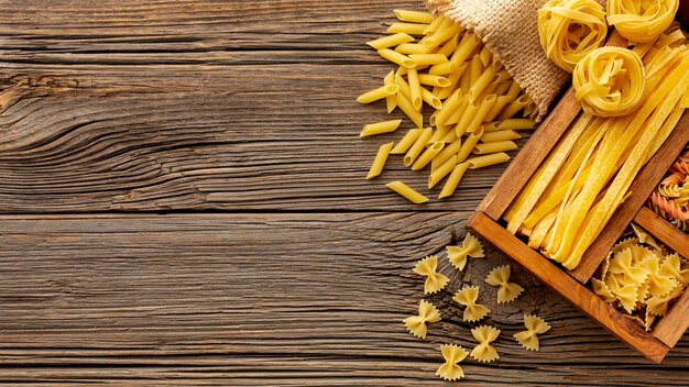 Uncooked pasta mix in wooden box on table