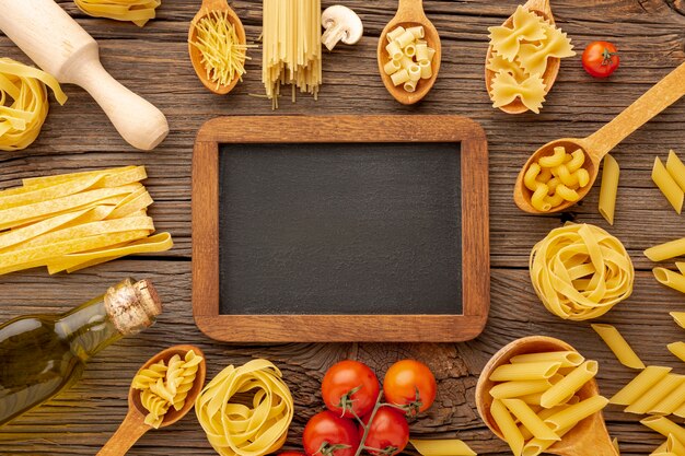 Uncooked pasta olive oil and tomatoes with blackboard mock-up