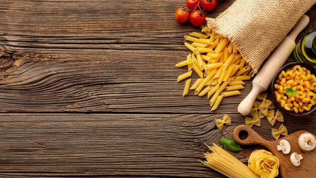 Uncooked pasta with mushrooms tomatoes and copy space